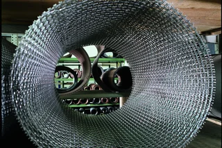Large roll of wire mesh in a close‑up view, stored in the production area of the Haver & Boecker Wire Weaving Division.