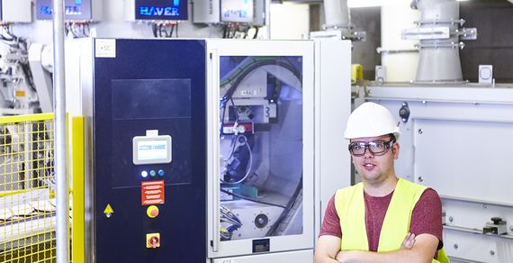 Mitarbeiter steht neben der Packmaschine mit RADIMAT®