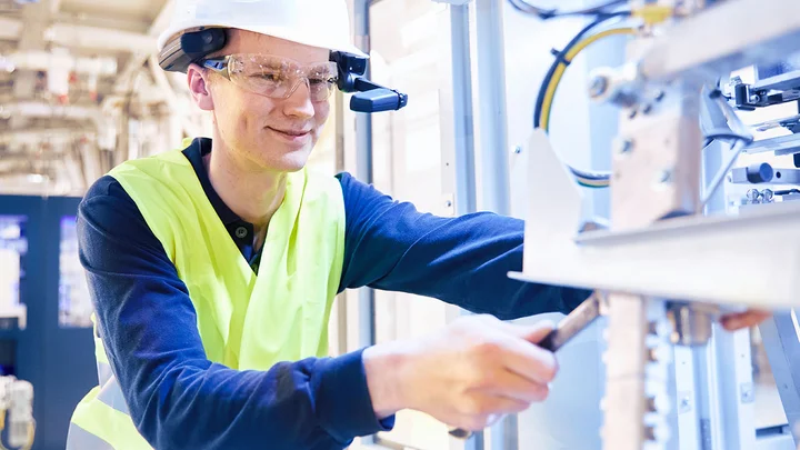 An employee checking a machine - avoid unexpected downtime with regular preventive maintenance