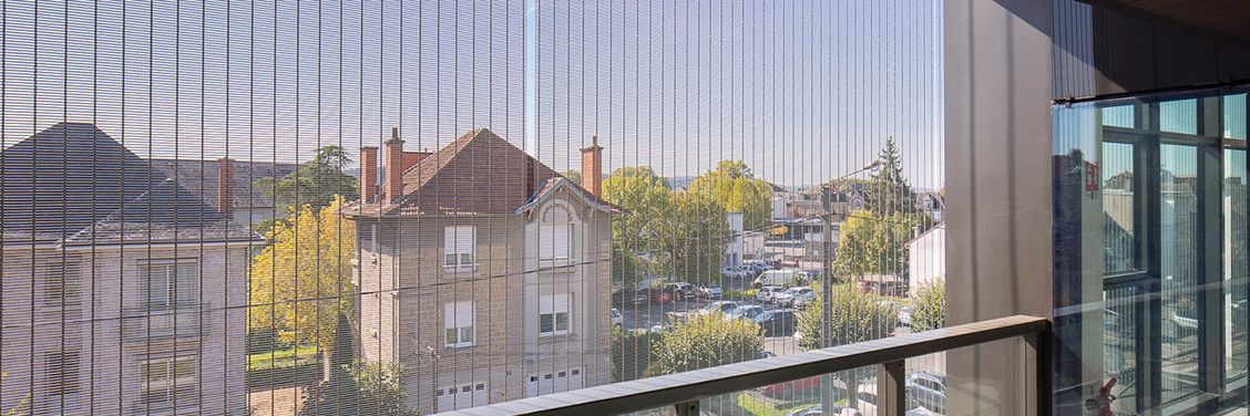 View through a sun protection facade made of metal mesh