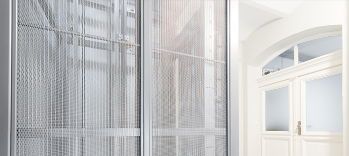 Elevator cladding with stainless steel mesh